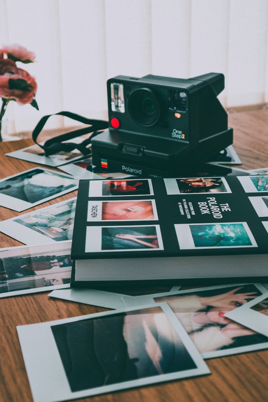 photo of polaroid camera near book