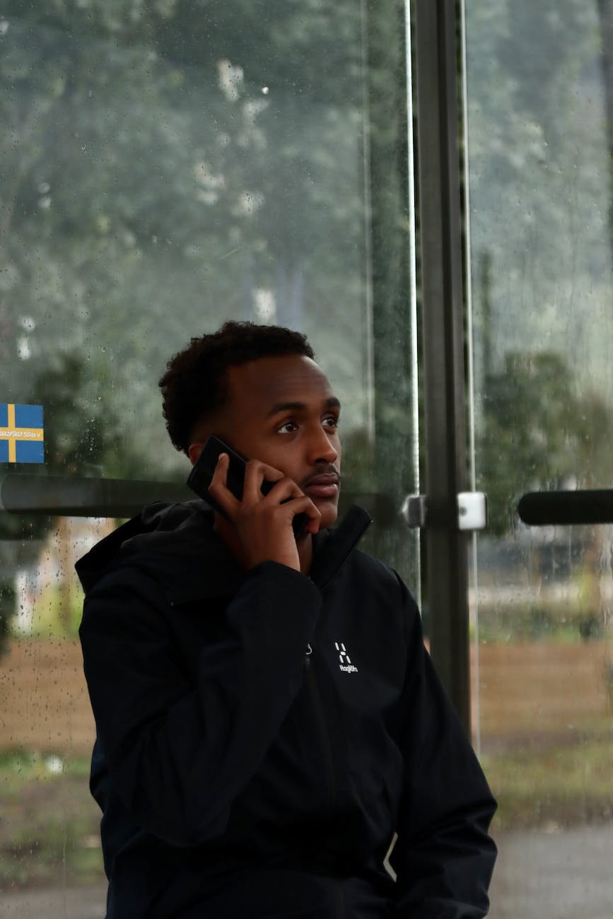 man wearing a black jacket on a phone call
