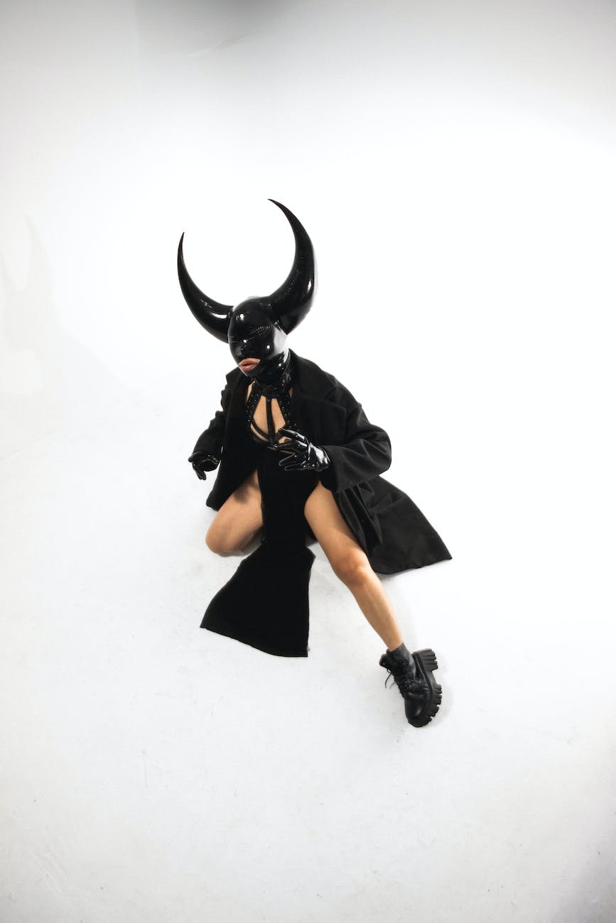 woman in a black costume with a cape and horns
