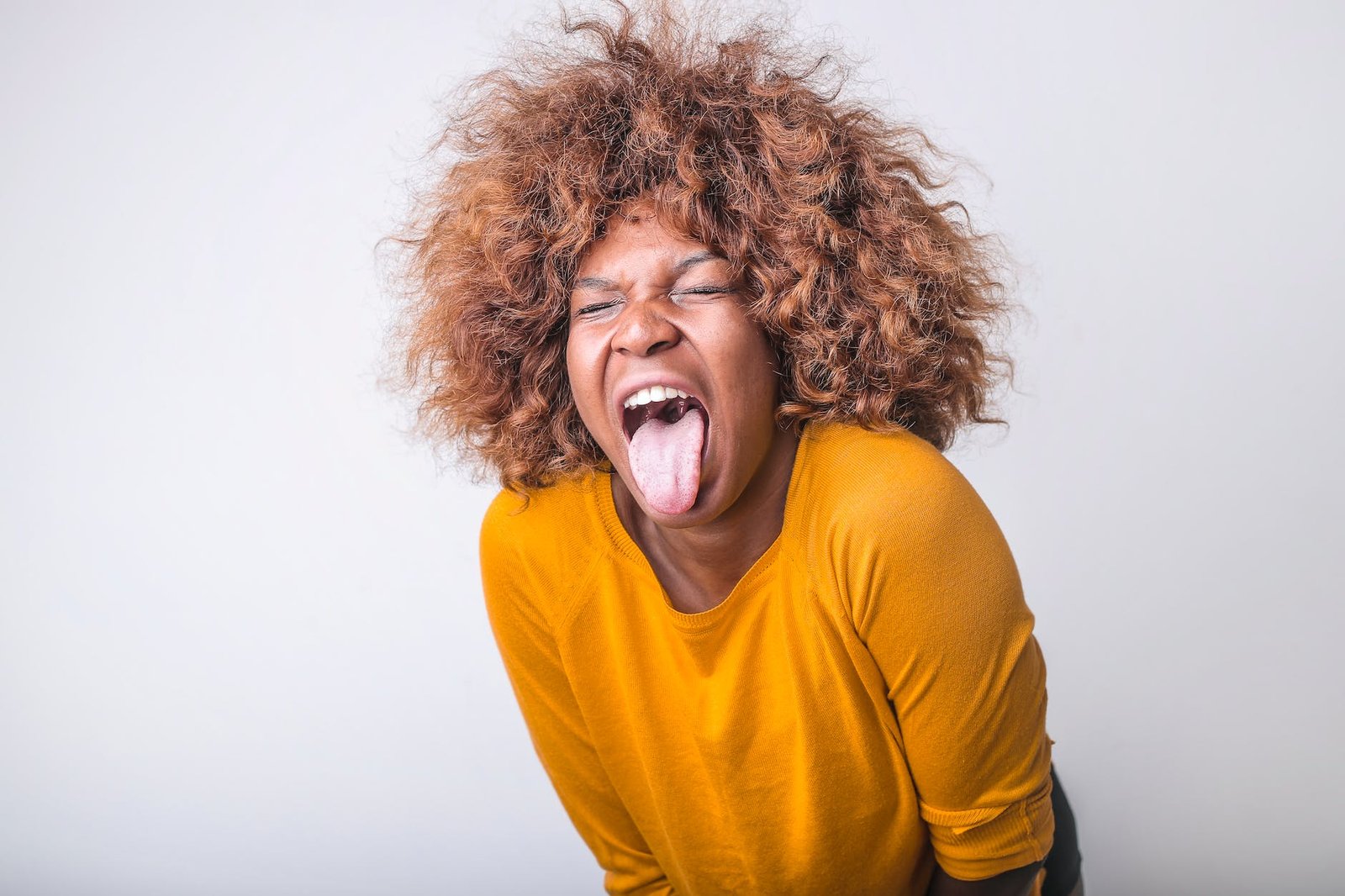 grimacing ethnic woman with tongue sticking out in studio