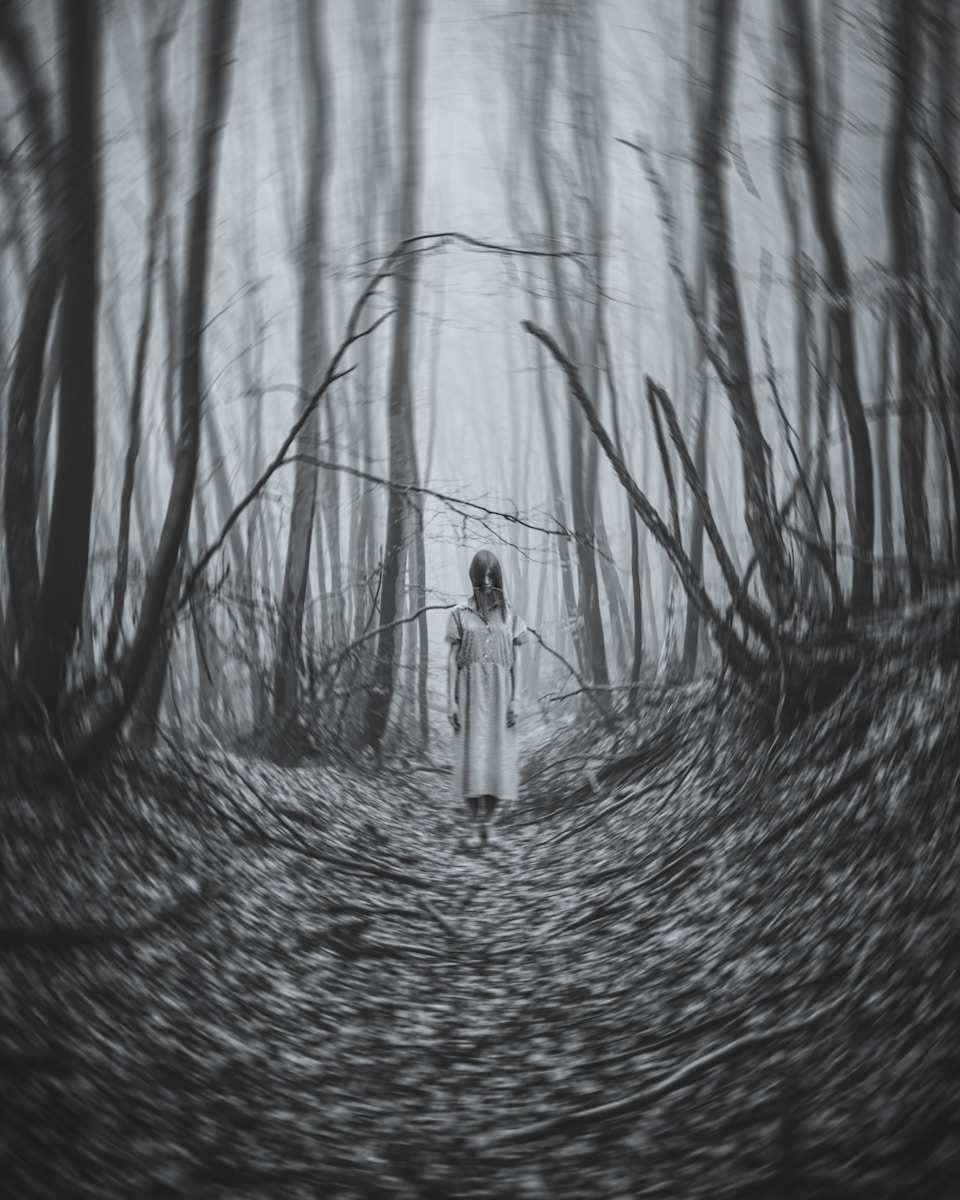 a woman standing in the middle of a forest